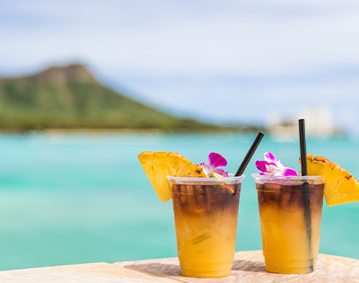 Yellow cocktails on a table overlooking a view of Diamond Head and ocean