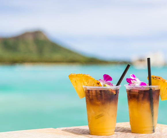 Yellow cocktails on a table overlooking a view of Diamond Head and ocean