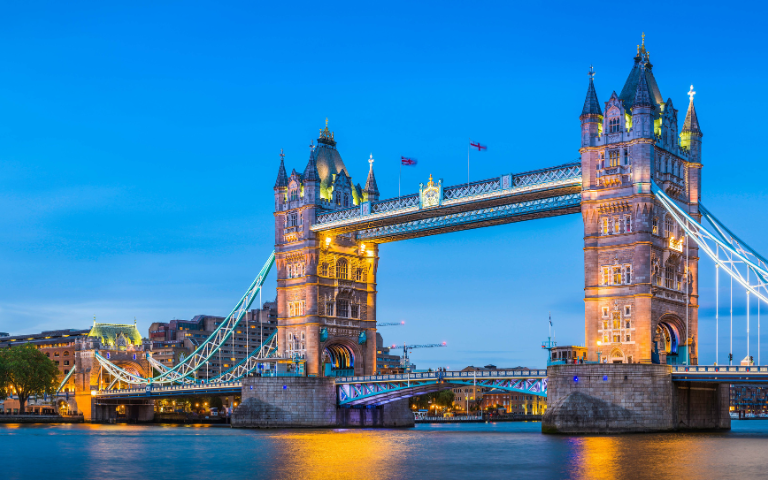 Illuminated Tower Bridge in London during twilight.