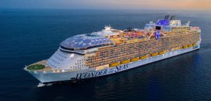 Royal Caribbean's Oasis Class Ship, Wonder of the Seas, sailing under a sunset sky.