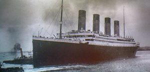 Historic image of the RMS Titanic sailing, featuring its four iconic smokestacks and a small tugboat nearby in a misty harbor.