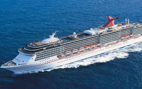 A large white cruise ship sails through deep blue ocean waters, leaving a foamy wake behind. The ship has multiple decks, lifeboats, and a prominent red funnel.