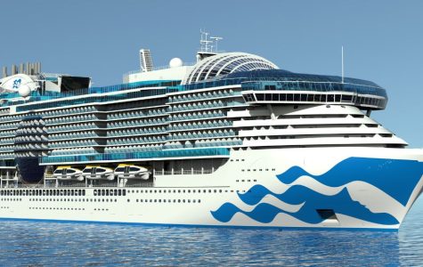 Large white and blue luxury cruise ship sailing on calm water under a clear blue sky.