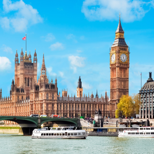 View of the Houses of Parliament and Big Ben clock tower along the River Thames in London on a clear day.