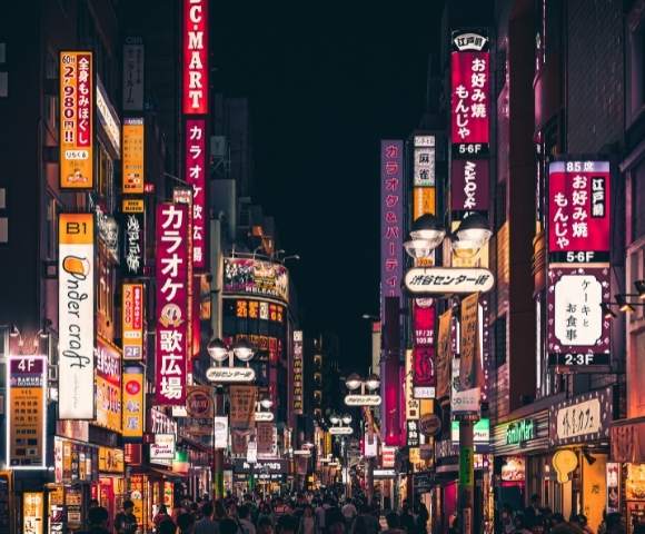Street in Tokyo at night with street signs lit up