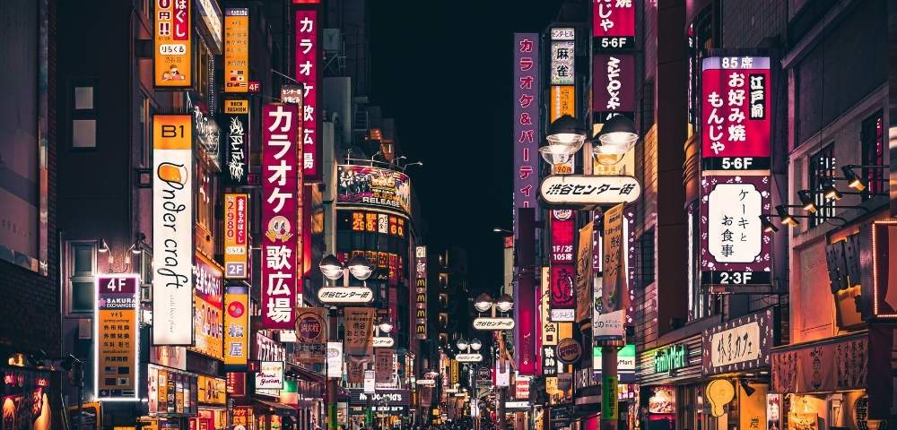 Street in Tokyo at night with street signs lit up