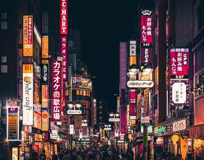 Street in Tokyo at night with street signs lit up