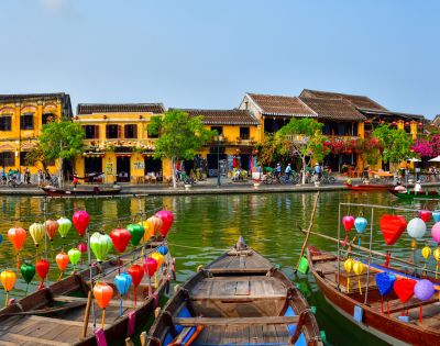 VIETNAM-HOI-AN-boats-on-a-river-with-houses-AdobeStock-261045461-MY-HOLIDAY