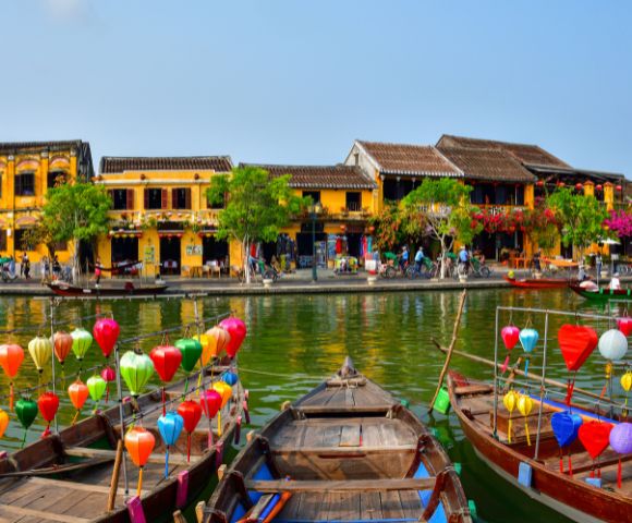 VIETNAM-HOI-AN-boats-on-a-river-with-houses-AdobeStock-261045461-MY-HOLIDAY