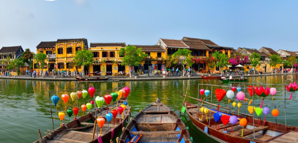VIETNAM-HOI-AN-boats-on-a-river-with-houses-AdobeStock-261045461-MY-HOLIDAY