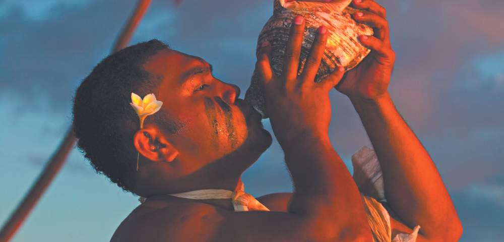 MYHOLIDAY-THE-WARWICK-FIJI-NATIVE-MAN-BLOWING-INTO-SHELL