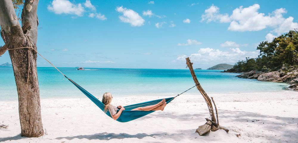 Daydream island beach woman in hammock relaxing on white sand beach