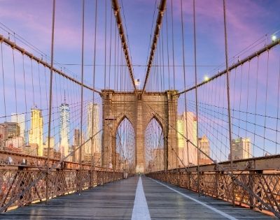 Sunset view on Brooklyn Bridge with New York City skyline in the background.