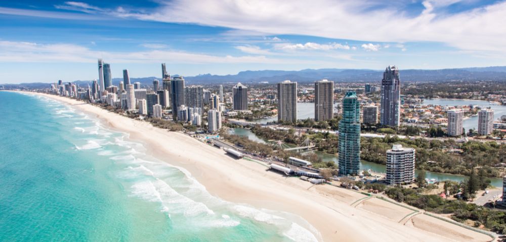 Birds eye view of gold coast with city, beach and mountains in the background