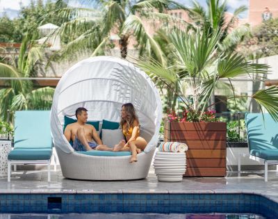 couple sitting on pool lounge at Outrigger Waikiki Beachcomber Hotel in Hawaii