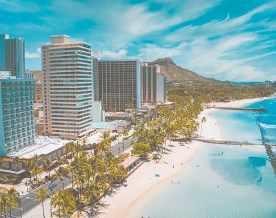 Oahu skyline with palm trees and beach with ocean retaining wall and view into the distance