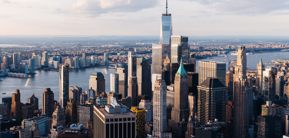Aerial view of a city skyline with skyscrapers and a river during golden hour.