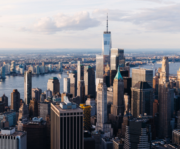 Aerial view of a city skyline with skyscrapers and a river during golden hour.