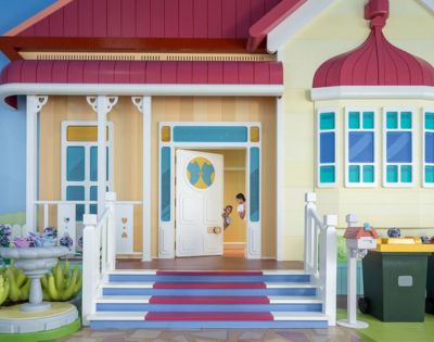 Two kids peaking through the house door at Bluey's World