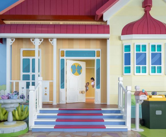 Two kids peaking through the house door at Bluey's World