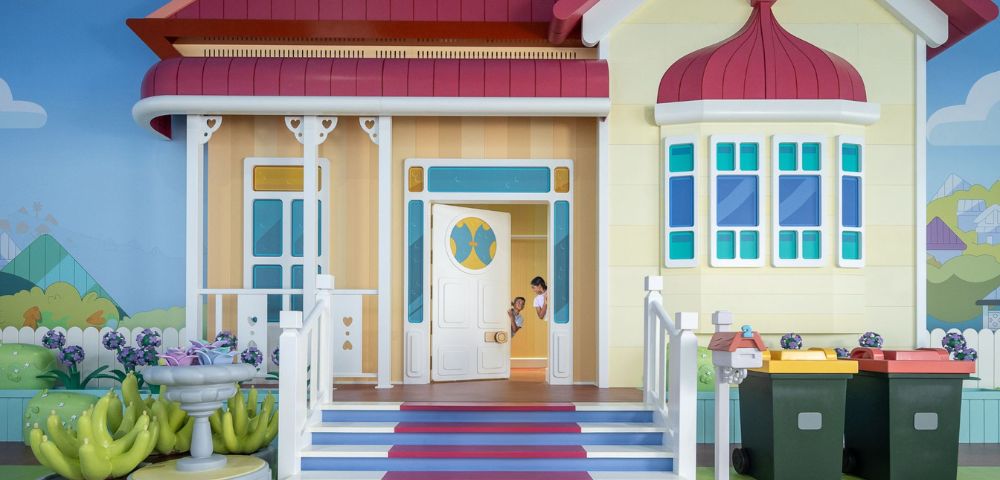 Two kids peaking through the house door at Bluey's World