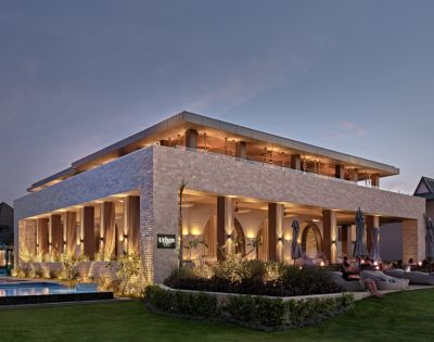 Crowne Plaza Fiji Nadi Bay Resort and Spa Modern outdoor restaurant at twilight with lit interiors and comfortable seating.