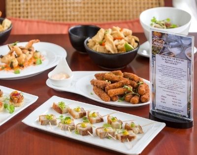 Assorted appetizers displayed on a table with a menu stand.