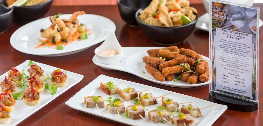 Assorted appetizers displayed on a table with a menu stand.