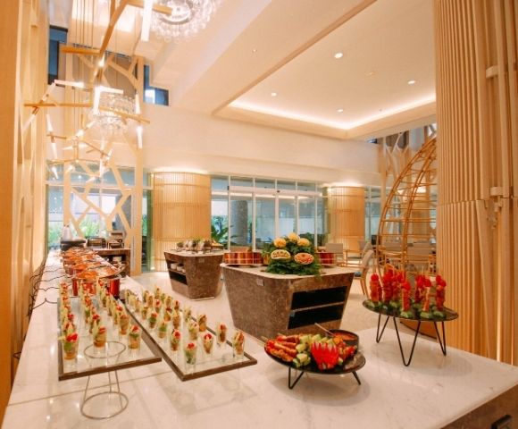 Elegant hotel lobby with a buffet setup and modern chandeliers.