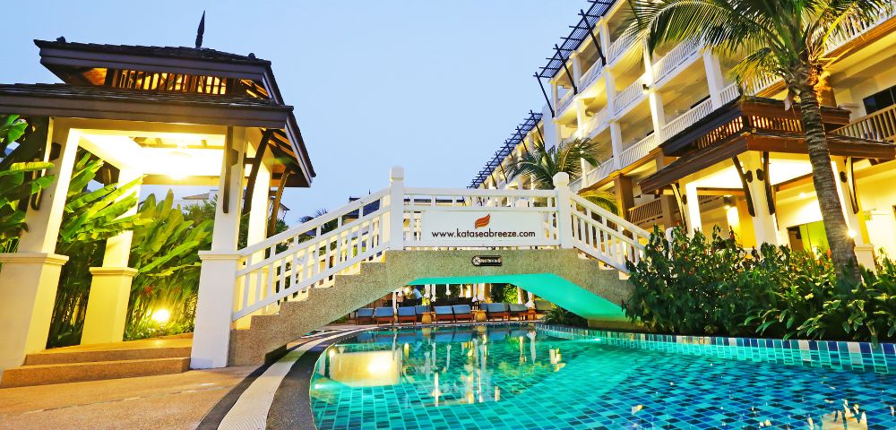 Luxury hotel with a bridge over a pool at twilight.