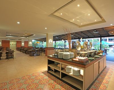 Spacious hotel buffet area with serving counters and seating arrangement, decorated with warm lighting.