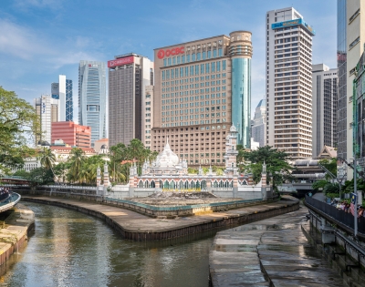 A vibrant cityscape featuring historic architecture alongside modern skyscrapers, with a river winding through the urban landscape.