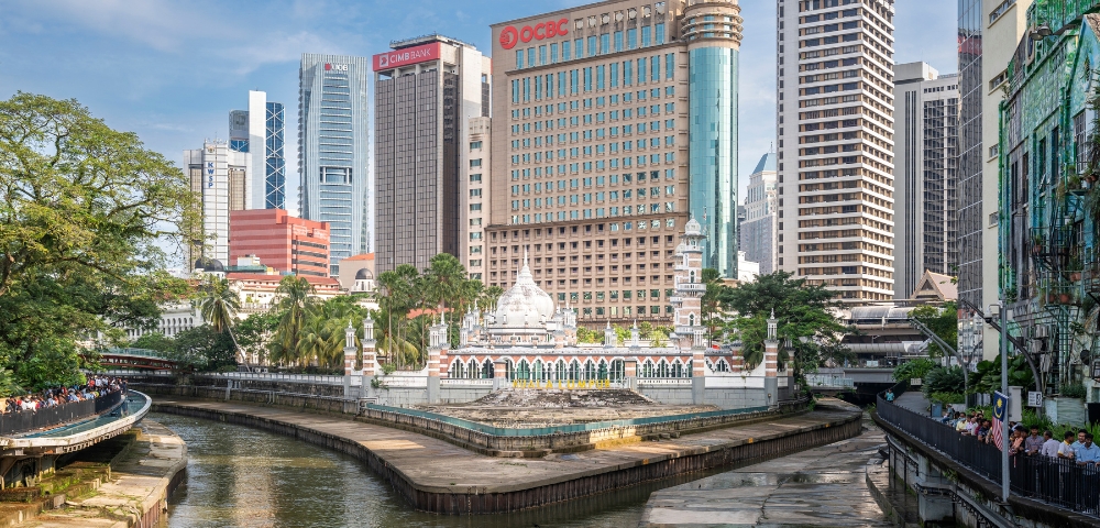 A vibrant cityscape featuring historic architecture alongside modern skyscrapers, with a river winding through the urban landscape.