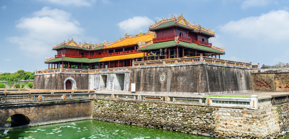 Imperial City in Vietnam, showcasing traditional architecture with colorful roofs, surrounded by a moat and lush green landscapes.