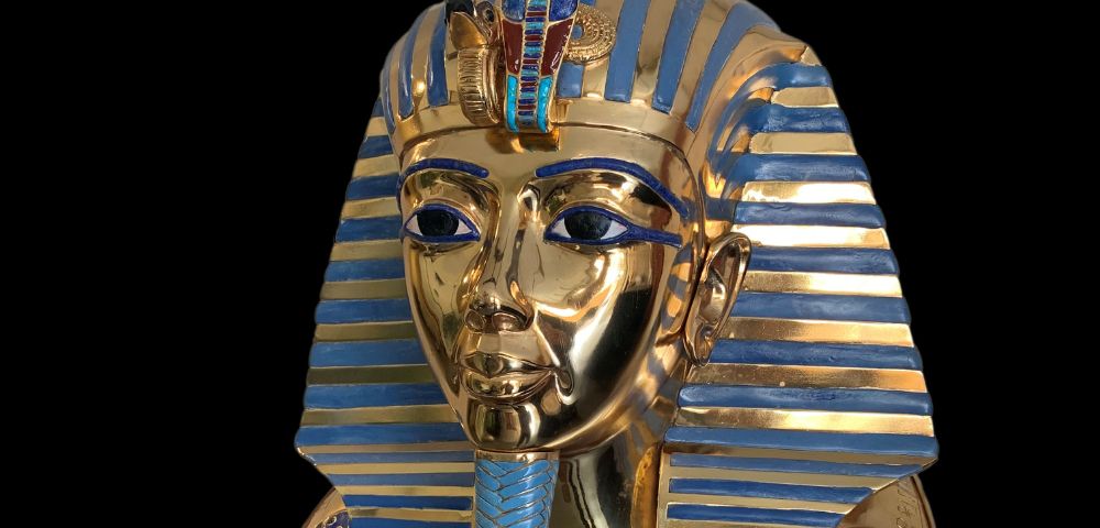 A detailed golden and blue striped sarcophagus showcasing intricate designs and Egyptian motifs, set against a dark background.