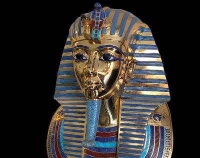 A detailed golden and blue striped sarcophagus showcasing intricate designs and Egyptian motifs, set against a dark background.
