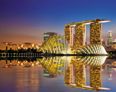 Skyline of Singapore at dusk, showcasing Marina Bay Sands and the Gardens by the Bay, reflecting on calm water.