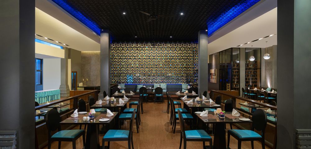 A dining area in a restaurant with blue chairs and tables, creating a vibrant atmosphere.