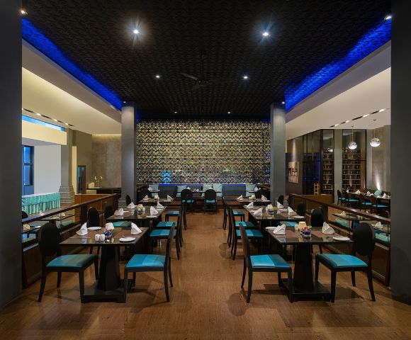 A dining area in a restaurant with blue chairs and tables, creating a vibrant atmosphere.