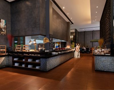 Modern restaurant interior featuring a buffet with diverse dishes, sleek decor, and diners enjoying a meal in a stylish ambiance.