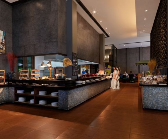 Modern restaurant interior featuring a buffet with diverse dishes, sleek decor, and diners enjoying a meal in a stylish ambiance.