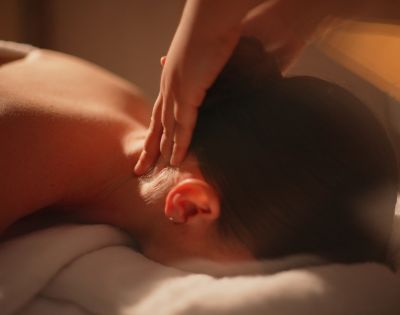 Relaxing massage scene featuring a person receiving a neck massage, with soft lighting and a serene ambiance.