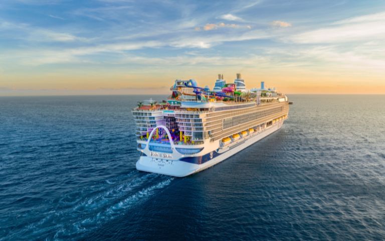 Royal Caribbean’s Icon of the Seas, an Icon Class cruise ship, sailing away on calm blue waters.