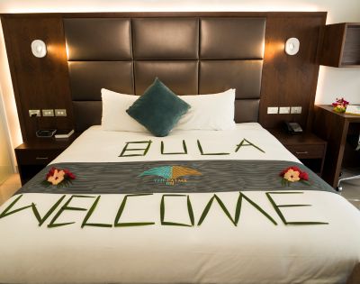 Hotel room with a large bed decorated with green leaf letters spelling 