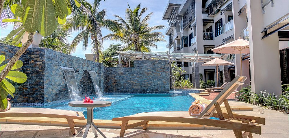 Tranquil poolside oasis with tropical foliage and modern architecture.