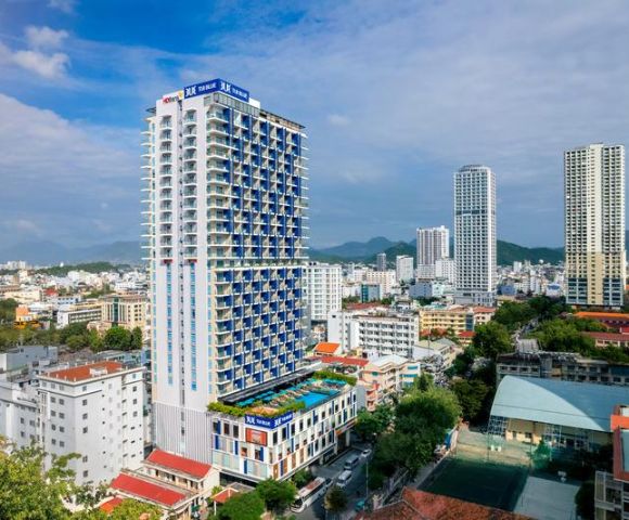 City skyline featuring a tall blue and white high-rise building labeled 