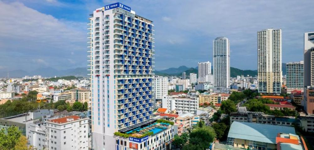 City skyline featuring a tall blue and white high-rise building labeled 