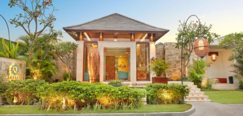 A charming modern villa with a sloped roof, surrounded by lush greenery and warm lighting, inviting entrance.