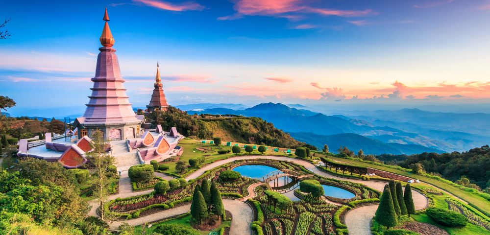 Aerial view of the Two Chedis in Doi Inthanon National Park, with the sun setting in the background.