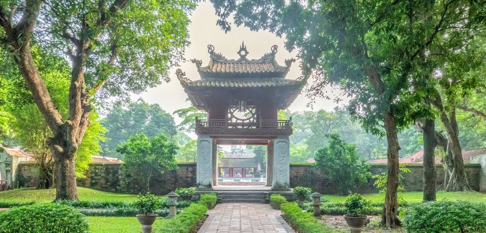 A serene view of Hanoi Temple of Literature and a green lush greenery sorrounding.